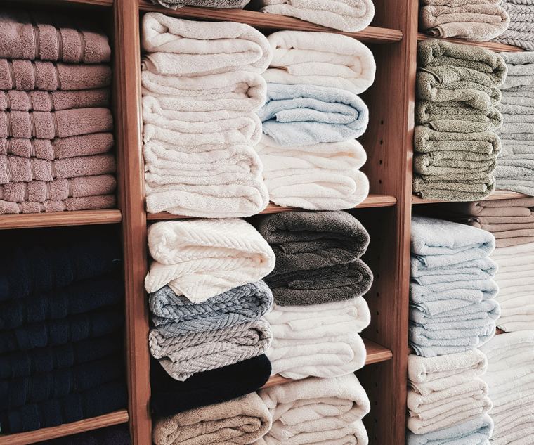Shelves of folded towels in many colours