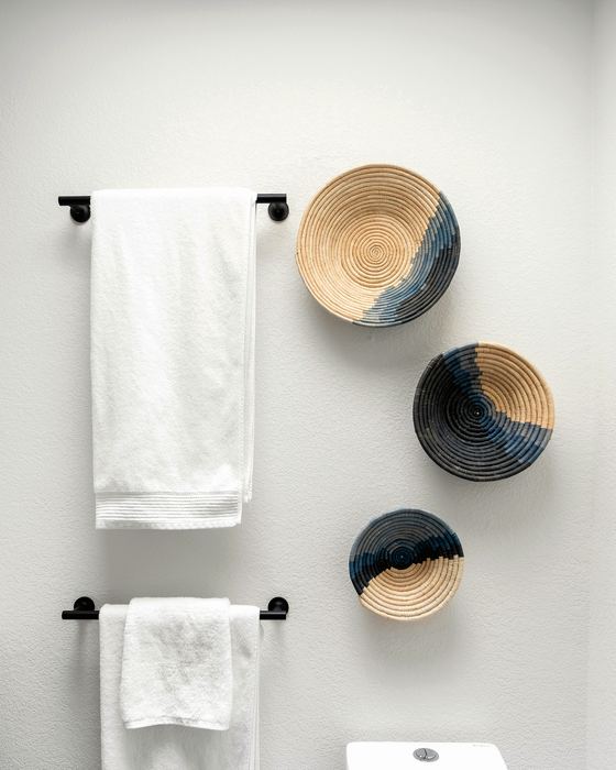 White towels on towel bars with woven wall baskets