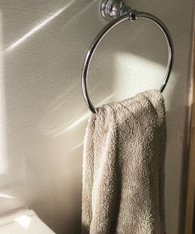 A towel hanging on a sunlit towel ring